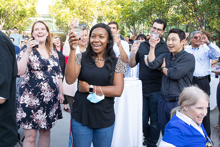 Several faculty raising glasses to toast the college